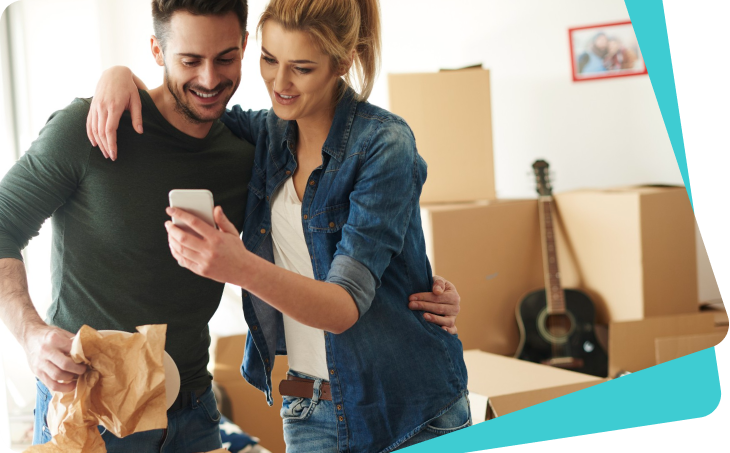 Couple looking at a phone among moving boxes